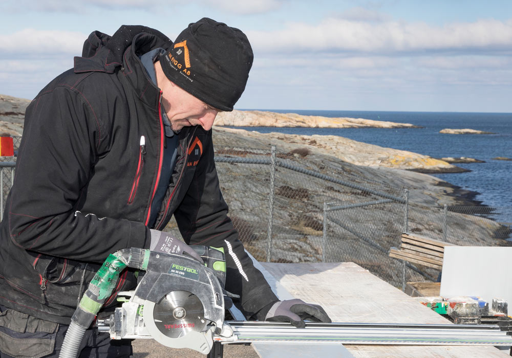 En man står vid havet med en cirkelsåg